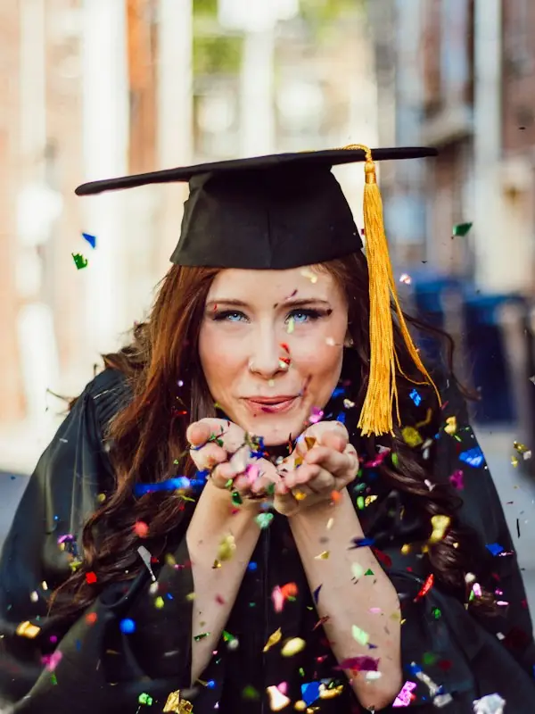 A woman blowing a handful of confetti