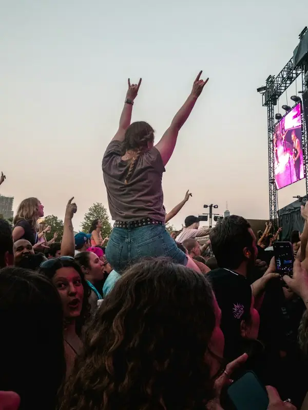 Someone up on a friend’s shoulders with arms in the air