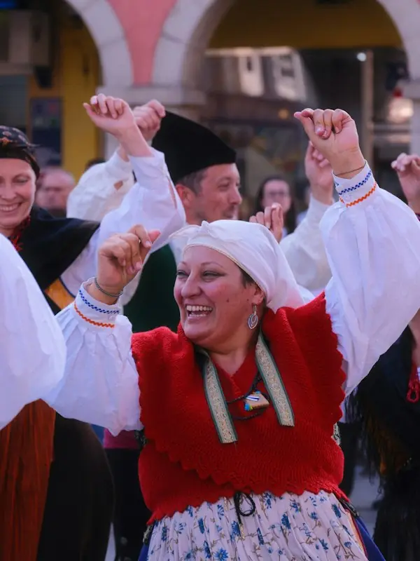 A dancer smiling mid-step in a folk costume