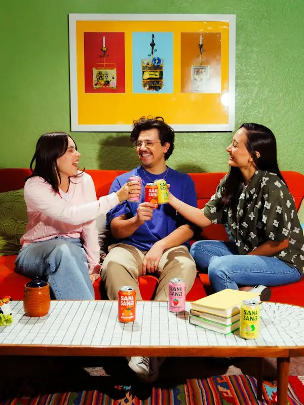 Friends clinking drinks in a bright living room