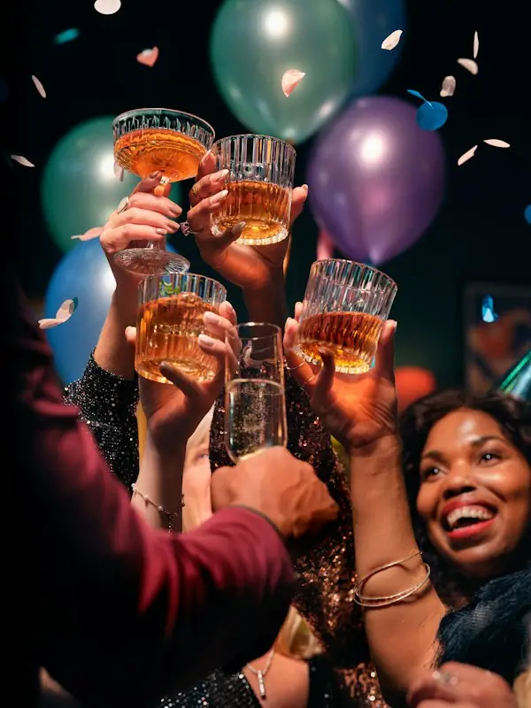Glasses raised under a cloud of balloons