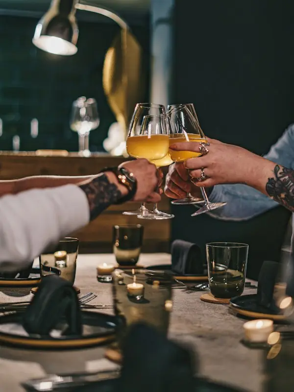 Friends raising wine glasses around a dinner table